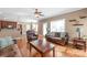 Open-concept living room with hardwood floors, a leather sofa set, and ample natural light at 5608 Old Town Ln, Gastonia, NC 28056