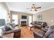 Comfortable living room featuring a fireplace, ceiling fan, hardwood floors and cozy leather furniture at 5608 Old Town Ln, Gastonia, NC 28056