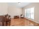 Well-lit room featuring hardwood floors, a cozy armchair, and a large window with blinds at 5608 Old Town Ln, Gastonia, NC 28056