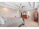 Bright main bedroom with a tray ceiling, plush carpet, dresser, and easy access to a walk-in closet at 5608 Old Town Ln, Gastonia, NC 28056