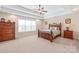 Spacious main bedroom featuring a tray ceiling, plush carpet, and a large window for natural light at 5608 Old Town Ln, Gastonia, NC 28056