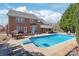 Gorgeous in-ground pool, covered patio, and lounge chairs create the perfect backyard oasis for relaxation and entertainment at 5608 Old Town Ln, Gastonia, NC 28056