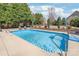 Beautiful in-ground pool featuring chairs and trees in a meticulously landscaped backyard with retaining wall at 5608 Old Town Ln, Gastonia, NC 28056