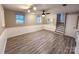 Finished basement area featuring updated floors, ceiling fan, and staircase at 7812 Highbanks Ct, Charlotte, NC 28212