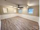 View of the finished basement space with updated floors and track lighting at 7812 Highbanks Ct, Charlotte, NC 28212