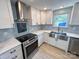 Bright kitchen featuring stainless steel appliances, stylish backsplash, quartz countertops, and ample cabinet space at 7812 Highbanks Ct, Charlotte, NC 28212