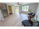 Inviting living room with neutral walls, hardwood floors, natural light, and a welcoming yellow front door at 7812 Highbanks Ct, Charlotte, NC 28212