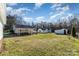 Expansive backyard with a large grass area, carport, and a detached garage at 810 Ashwood St, Kannapolis, NC 28081