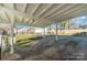 Covered carport structure with gravel parking area and access to the fenced in backyard at 810 Ashwood St, Kannapolis, NC 28081