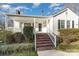 Inviting home featuring a covered porch, black front door, and brick stairway at 810 Ashwood St, Kannapolis, NC 28081