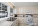 Bright kitchen featuring white cabinets, stainless steel sink, and modern appliances at 810 Ashwood St, Kannapolis, NC 28081