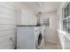 Bright laundry room with white cabinets, and includes a front load washer and dryer at 810 Ashwood St, Kannapolis, NC 28081
