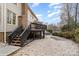 Backyard view of a two-story house with a deck, stone driveway, and natural surroundings at 8909 Abberley Ct, Huntersville, NC 28078