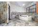 Bathroom with jetted tub, decorative tile accents, and arched window at 8909 Abberley Ct, Huntersville, NC 28078