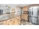 Open kitchen view features light wood cabinets, stainless steel refrigerator, and mosaic backsplash at 8909 Abberley Ct, Huntersville, NC 28078