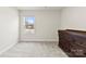 Bright bedroom features a window, carpet flooring and a dark dresser with ample storage space at 916 Clementine Rd, Monroe, NC 28110