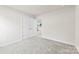 Bright bedroom with neutral carpet and paint, a double door closet, and a view to the living area at 916 Clementine Rd, Monroe, NC 28110