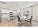 A modern kitchen with white cabinets, stainless steel appliances, an island with seating, and an adjacent dining area at 916 Clementine Rd, Monroe, NC 28110