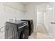 Bright laundry room featuring tile floors, black washer and dryer, and access to closet at 916 Clementine Rd, Monroe, NC 28110
