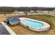 Aerial view of a community swimming pool with a clubhouse, fenced perimeter, and well-maintained landscaping at 916 Clementine Rd, Monroe, NC 28110