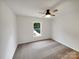Spacious bedroom with neutral carpet, ceiling fan, and window to the backyard at 10312 Hugue Way, Charlotte, NC 28214
