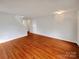 Spacious living room with hardwood floors, neutral paint, and staircase at 10312 Hugue Way, Charlotte, NC 28214