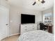 Bright bedroom featuring a ceiling fan, TV, dresser, and a sun-filled window at 105 Burlingame Ct # B, Mooresville, NC 28117