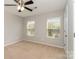 Clean and bright bedroom with neutral carpet, ceiling fan, and natural light from the window at 105 Burlingame Ct # B, Mooresville, NC 28117