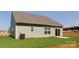 The backyard has a grassy lawn with the home's exterior composed of green siding at 111 Tradesmen Trl # 75, Troutman, NC 28166