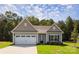 Charming single-story home featuring a two-car garage, stone accents, and a well-manicured lawn at 111 Tradesmen Trl # 75, Troutman, NC 28166