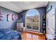 Cozy bedroom features an arch window, hardwood floors, and skateboard wall decor at 1232 Pressley Downs Se Dr, Concord, NC 28025