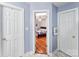 Hallway view into a bedroom with hardwood floors and a ceiling fan at 1232 Pressley Downs Se Dr, Concord, NC 28025