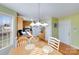 Bright kitchen area featuring white appliances, natural wood cabinets, and a charming dining space at 1232 Pressley Downs Se Dr, Concord, NC 28025