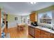 Open kitchen and dining area with wood floors, stainless steel dishwasher, and large windows at 1232 Pressley Downs Se Dr, Concord, NC 28025