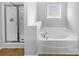 Bright bathroom features a soaking tub, separate shower, and large window for natural light at 12332 Flatbush Dr, Huntersville, NC 28078