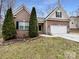 Charming brick home featuring a two-car garage, and lovely, mature landscaping at 12332 Flatbush Dr, Huntersville, NC 28078