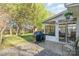 This patio has a grill and seating, surrounded by green grass and mature trees at 12421 Poplar Forest Dr, Charlotte, NC 28278