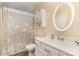 Cozy bathroom featuring patterned shower curtain, round mirror, and white vanity at 12421 Poplar Forest Dr, Charlotte, NC 28278