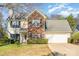 Charming two-story home features a blend of siding and brick, complemented by a well-maintained lawn and mature landscaping at 12421 Poplar Forest Dr, Charlotte, NC 28278