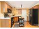 Traditional style kitchen with oak cabinets, black appliances, and a mobile kitchen island at 12421 Poplar Forest Dr, Charlotte, NC 28278