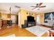 Open living room with hardwood floors, a large television, and seamless access to the kitchen area and backyard at 12421 Poplar Forest Dr, Charlotte, NC 28278