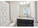 Full bathroom featuring granite countertops, dark cabinets, and a shower-tub combo with a floral shower curtain at 12461 Bryton Ridge Pkwy, Huntersville, NC 28078