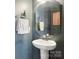 Stylish powder room featuring a pedestal sink, octagon mirror, and a glass shelf at 12461 Bryton Ridge Pkwy, Huntersville, NC 28078