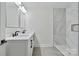 Modern bathroom featuring double sink vanity and white marble-look tiled shower with shower caddy at 126 Hemphill Ave, Chester, SC 29706