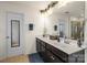 Bathroom featuring double sinks, dark cabinets, large mirror with decorative lighting, and tile floors at 12614 Chantrey Way, Huntersville, NC 28078
