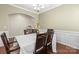 Traditional dining room featuring a chandelier, wainscoting, and seating for six at 12614 Chantrey Way, Huntersville, NC 28078