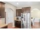 Kitchen featuring stainless steel appliances and dark wood cabinets, archway leading to dining area at 12614 Chantrey Way, Huntersville, NC 28078