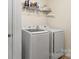 This laundry room has modern front loading washer and dryer with shelving at 12614 Chantrey Way, Huntersville, NC 28078