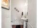 Cozy powder room with a pedestal sink, framed artwork, and wood-look flooring at 12614 Chantrey Way, Huntersville, NC 28078