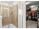 Modern bathroom with glass shower and walk-in closet featuring custom shelving at 12614 Chantrey Way, Huntersville, NC 28078